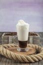 Caffe mocha with whipped cream. Latte macchiato in a tall glass. Glass of coffee latte and coffee beans on a dark background. ÃÂ¡ Royalty Free Stock Photo